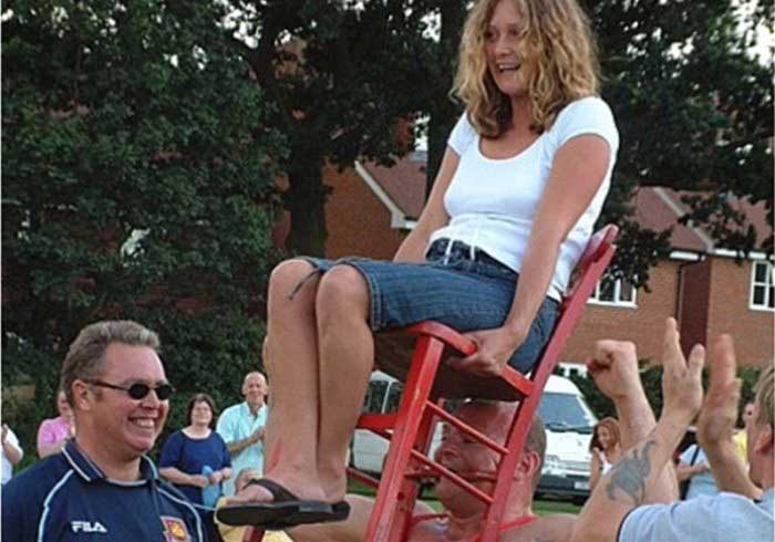 Strongman Holding Lady on a Chair
